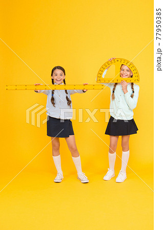 Learning school geometry. School children with measuring instruments on yellow background. Learning school geometry. School children with measuring instruments on yellow background. 77950385