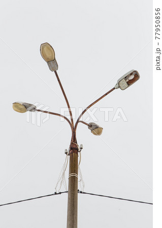 A pillar of street lighting with several lanterns against a gray sky. A pillar of street lighting with several lanterns against a gray sky. 77950856