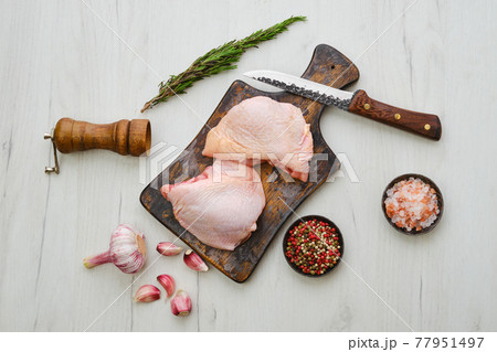 Raw chicken thighs on cutting board ready for cooking 77951497