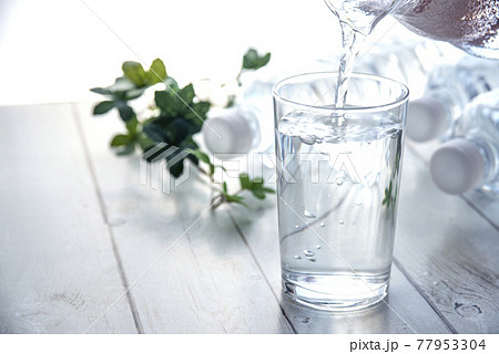 テーブルに置いたペットボトルとコップ テーブルに置いたペットボトルとコップ 77953304