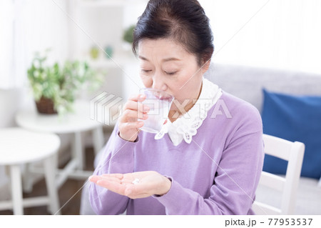 薬を飲むシニア女性 77953537