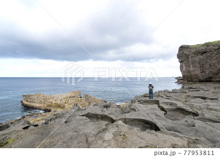 徳之島の天城町の犬の門蓋で動画撮影する女性フォトグラファー 徳之島の天城町の犬の門蓋で動画撮影する女性フォトグラファー 77953811