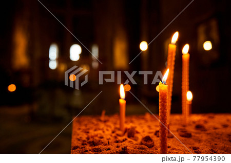 Burning candles in a church on a dark background. Memorial Candles. Burning Candles In The Temple, Sacred Fire. Candles Burning in Dark Church 77954390