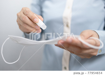 Female holding a bottle of perfume natural scent aroma,dripping the perfume into medical mask to breathe fresh while wearing it,refresh or reduce the bad breath,bad smell problem stuck in a face mask Female holding a bottle of perfume natural scent aroma,dripping the perfume into medical mask to breathe fresh while wearing it,refresh or reduce the bad breath,bad smell problem stuck in a face mask 77954654