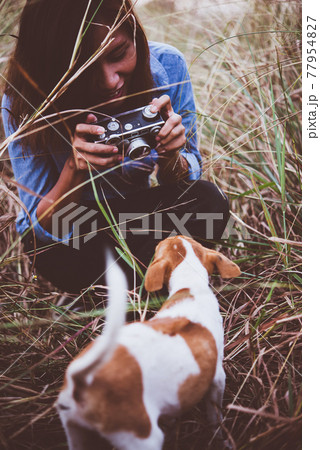 Shot of hipster woman taking a snapshot of her dog on her vintage camera. 77954827
