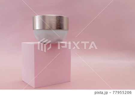 Mockup moisturizer cream in jar standing on pedestal on pastel pink background 77955206