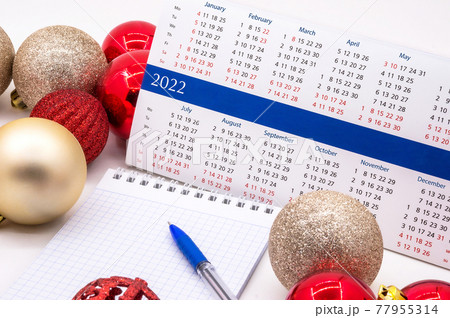 Calendar 2022 and Christmas decorations. Planning for next year. Notebook, New Year's celebration. 77955314