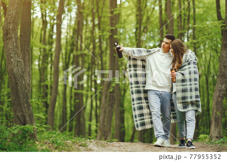 Beautiful couple spend time in a spring forest Beautiful couple spend time in a spring forest 77955352