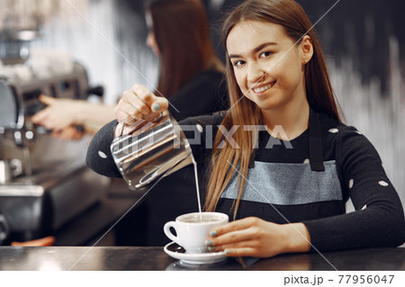 Young barista girl makes coffee and smiles 77956047
