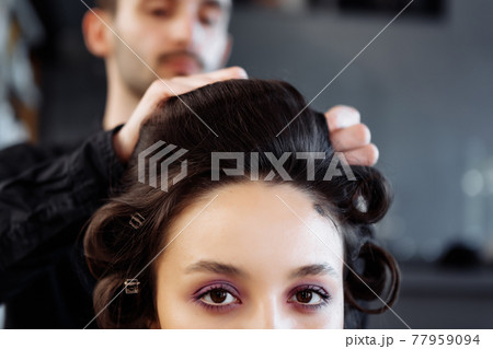 Stylist to make a hairstyle in the style of the 80's. Laying. hair. Stylist to make a hairstyle in the style of the 80's. Laying. hair. 77959094