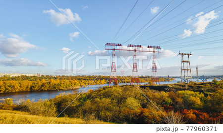 high voltage pillar, overhead power line, industrial background. power lines on the river 77960371