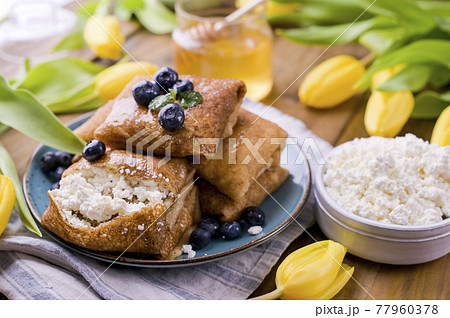 Large traditional Russian pancakes with berries and honey on a wooden table. Baking for the spring 77960378