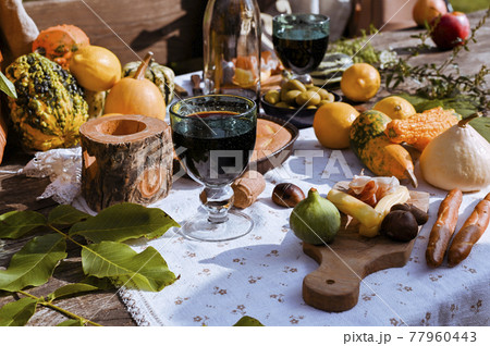 Table prepared for lunch in autumn nature, picnic . Harvest, autumn lunch, Wine and glasses. Outdoor Table prepared for lunch in autumn nature, picnic . Harvest, autumn lunch, Wine and glasses. Outdoor 77960443
