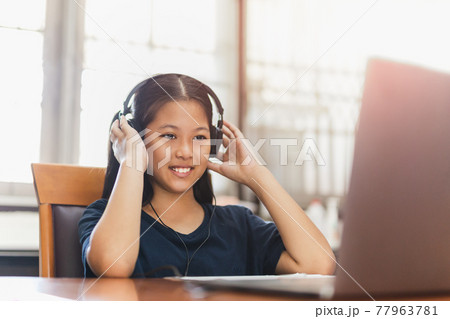 Asian young girl with headphone student using laptop study at home. 77963781