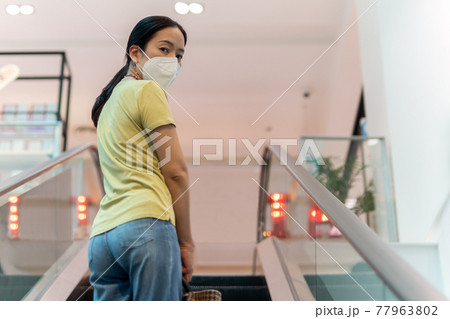 Woman with protective mask looking back at camera. 77963802