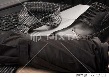 Close-up of a man's umbrella, tie and shoes. Close-up of a man's umbrella, tie and shoes. 77964665