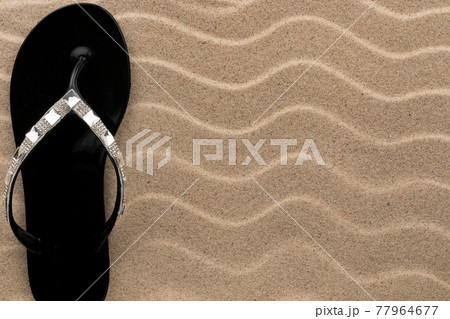 Sandy beach background with flip flops. Summer concept. Sandy beach background with flip flops. Summer concept. 77964677