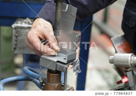 Close up of a metal element being spot-welded by a factory worker. Industry concept. 77964837