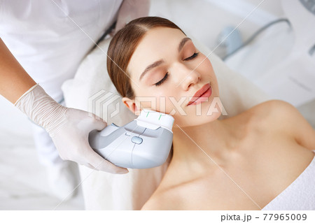 Woman getting facial lifting therapy in beauty salon Woman getting facial lifting therapy in beauty salon 77965009