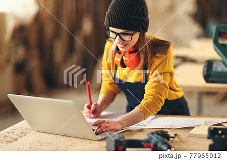 Artisan woman working in carpentry workshop 77965012