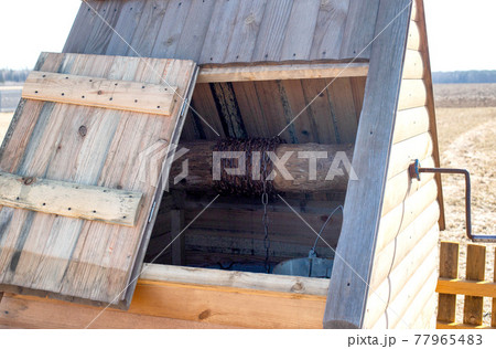 Beautiful and modern wooden well with water in a village in nature, background Beautiful and modern wooden well with water in a village in nature, background 77965483