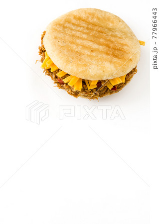 Arepa with shredded beef and cheese isolated on white background. 77966443