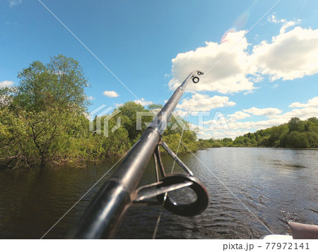 fishing rod on the background of the river and vegetation on the shore 77972141