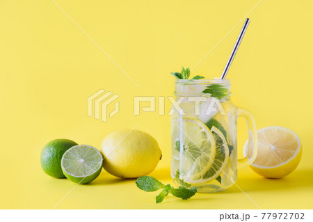 Fresh summer lemonade with lemon, lime, orange and mint on yellow background. 77972702