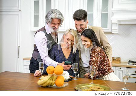 Family members looking at photos taken during birthday celebration 77972706