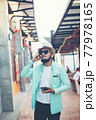Hipster man listening music with his smartphone on the street in urban. 77978165