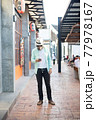 Hipster man listening music with his smartphone on the street in urban. 77978167