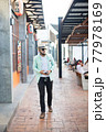 Hipster man listening music with his smartphone on the street in urban. 77978169