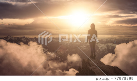 Fantasy Adventure Composite with a Woman on top of a Mountain Cliff 77978599