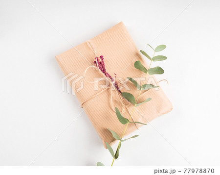 Wrapped gift boxes in craft paper with dried flowers decor Wrapped gift boxes in craft paper with dried flowers decor 77978870