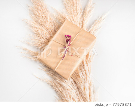 Gift box wrapped in craft paper with dried flowers Gift box wrapped in craft paper with dried flowers 77978871