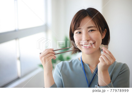 百円玉3枚と箸を持つ女性社員　300円ランチイメージ 77978999