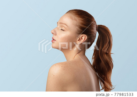 Sensual Red-Haired Young Lady Posing Shirtless, On Blue Background, Side-View 77981533