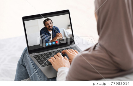 Online Communication. Woman In Hijab Having Video Call On Laptop With Husband Online Communication. Woman In Hijab Having Video Call On Laptop With Husband 77982014