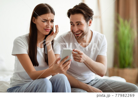 Jealous Husband Showing Cheating Wife Phone Accusing Of Infidelity Indoor 77982269