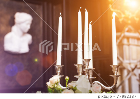 candles in candelabrum on the festive table 77982337