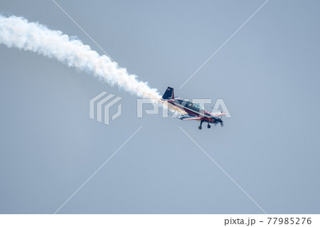 Kubinka, Moscow Region, Russia - May 12, 2021: Silhouette of an airplane with trail of smoke behind against background of blue sky. Air show background. 77985276