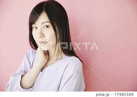 Beautiful asian woman on pink background 77985389