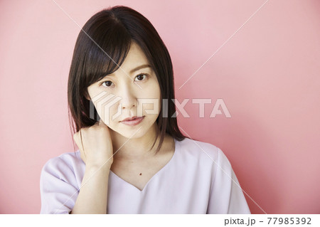 Beautiful asian woman on pink background Beautiful asian woman on pink background 77985392