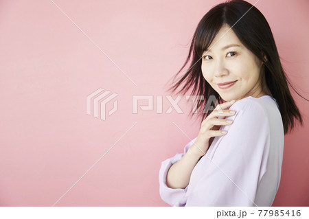 Beautiful asian woman on pink background Beautiful asian woman on pink background 77985416