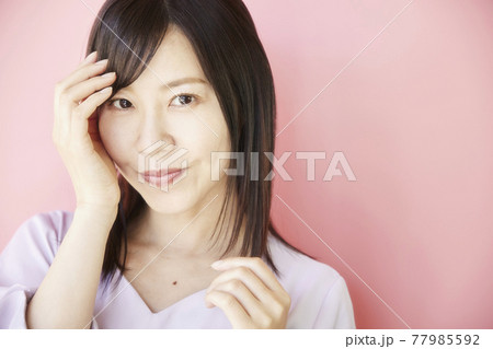 Beautiful asian woman on pink background Beautiful asian woman on pink background 77985592