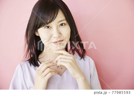 Beautiful asian woman on pink background Beautiful asian woman on pink background 77985593