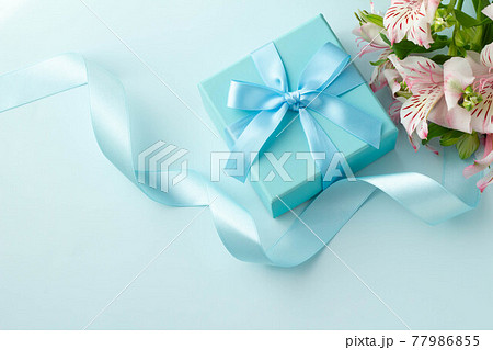 水色のリボンで装飾された箱とピンクのアルストロメリアのプレゼントのイメージ 77986855