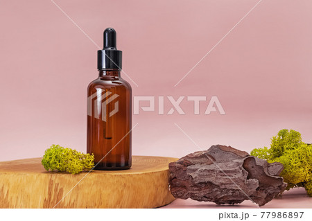 Bottle with pipette, scincare serum or oil, on wooden stand. Bottle with pipette, scincare serum or oil, on wooden stand. 77986897