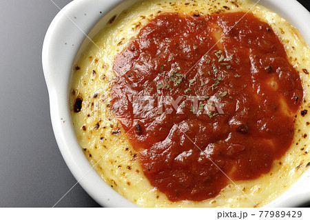 溶けて焦げ目がついたたっぷりチーズのドリア、グラタンを黒背景で撮影（俯瞰） 77989429