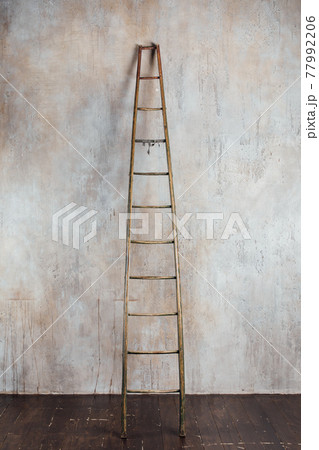 old aged wooden ladder on concrete wall background old aged wooden ladder on concrete wall background 77992206